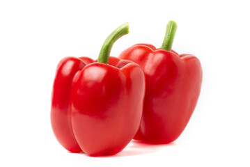 Isolated Two Red Bell Pepper on White. Two vibrant, glossy red bell peppers, one standing upright and another resting beside it, perfectly isolated on a pure white background, ideal for culinary.
