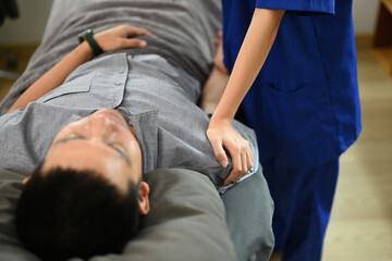 Physiotherapist examining shoulder joint of male patient and checks mobility of movements inside a clinic