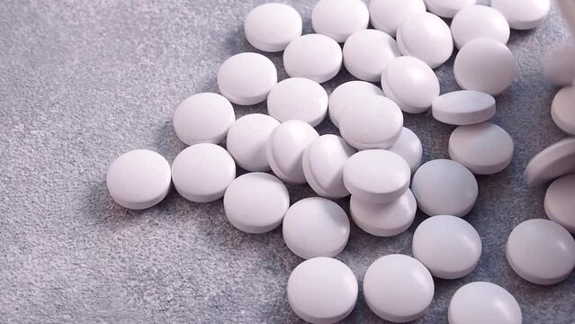 Pour the white pills out of the vials. The concept of health, treatment. Medicines and vitamins. Close-up