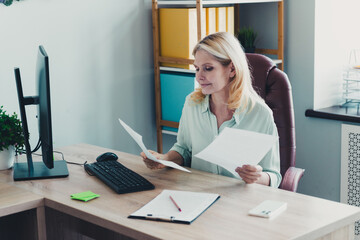 Photo of charming woman reading document project cv resume in modern office room indoors workplace workshop