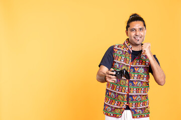 Happy gamer celebrating after winning game on gaming console, studio background. Delighted man...
