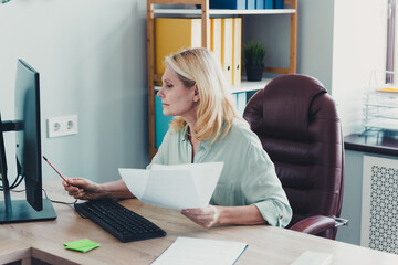 Photo of lovely charming nice woman reading document project computer in modern office room indoors...