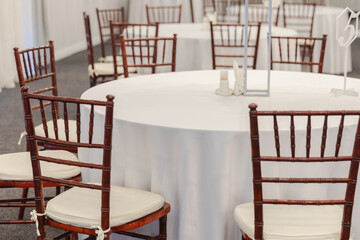 Decorated interior for festive event. Fancy table set for dinner in restaurant, luxury interior background. Wedding elegant banquet decoration arranged by catering service