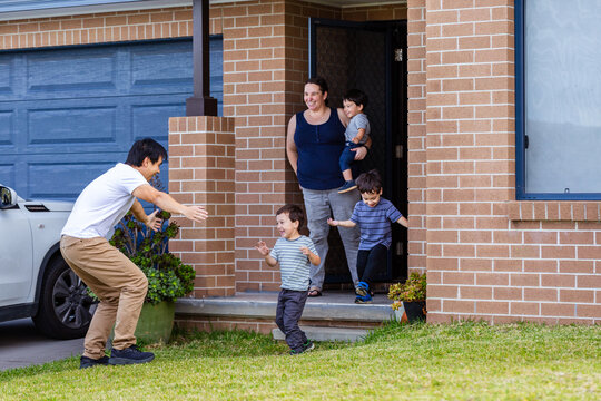 Chinese Australian dad arriving home from work greeting family