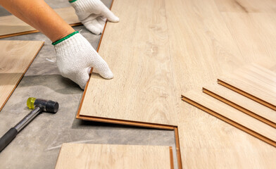 Fototapeta premium Worker Installing Interlocking laminate floor, home renovation.