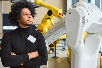 Engineer observing robotic arm in modern industrial setting