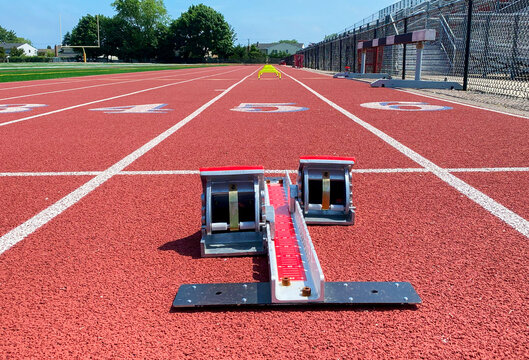 Low angle view of runners starting blocks in lne on a track