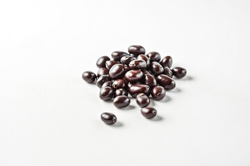 Close-up of a Pile of Dark Brown Beans on a White Background