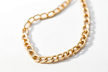 Closeup of a shiny gold chain on a white background