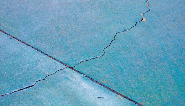 Crack lines texture on the old green washed gravel flooring surface of outdoors basketball court background