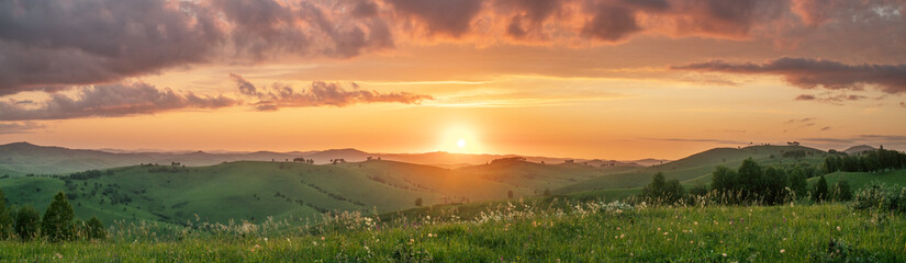 Evening rural landscape, the setting sun, sunset, meadows and hills, panoramic view
