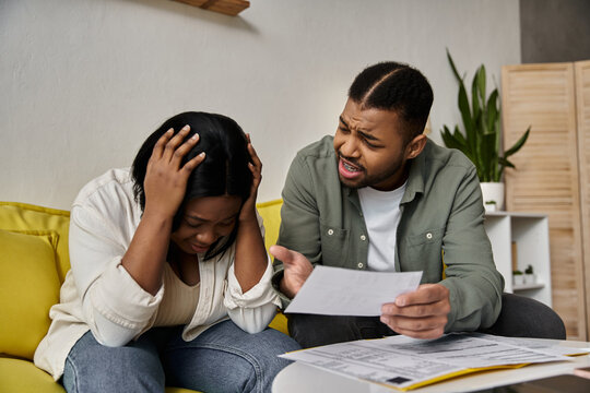 A young African American couple at home in a difficult financial situation.