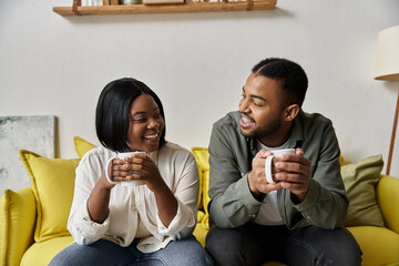 A loving African American couple enjoys a cozy coffee date at home.