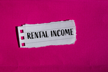 Rental income words written on ripped white paper piece with pink background. Conceptual rental income symbol. Copy space.