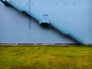 A set of stairs ascending a large blue wall
