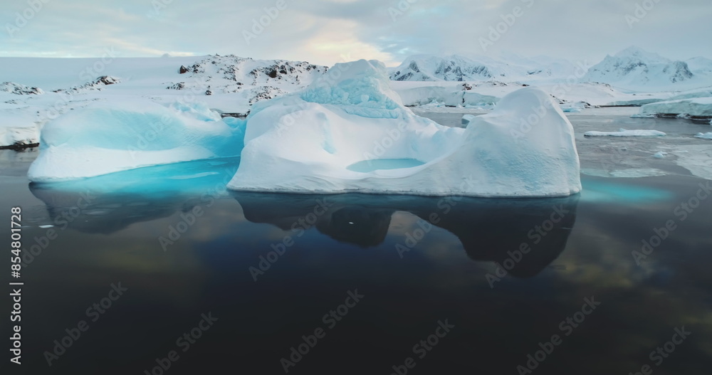 Wall mural Meting ice glacier in Antarctica close up panorama. Blue water ice cave iceberg floating, reflected in ocean water. Environment ecological issue of global warming. Polar climate change at winter day. - Wall murals