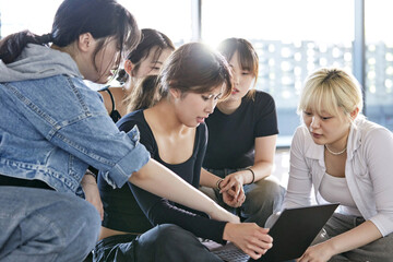 앉아서 태블릿을 보며 모니터를 하는 여성 댄서들 