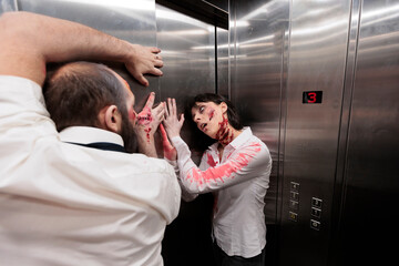 Reanimated corpses stuck in office building elevator, trying to escape to infect more people and doom humanity. Creepy undead monsters covered in scars trapped in escalator, pulling on metallic doors