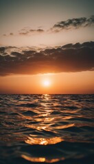 Obraz premium A serene sunset over a calm lake, with the sun casting a golden glow on the water and dark clouds adding contrast to the sky