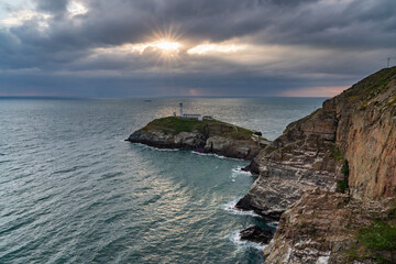 Sun beams around South Stack Lighthouse