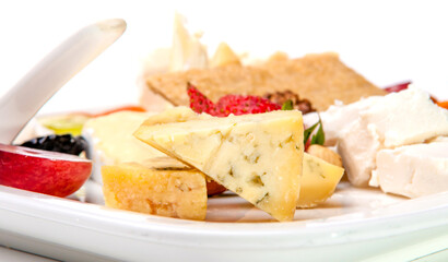 Cheese plate beautifully laid appetizer in a restaurant, Cheese, nuts and berries on a white background.