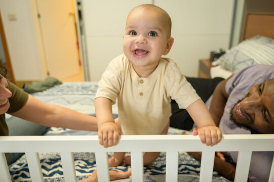 Multiracial family enjoying time with their joyful baby
