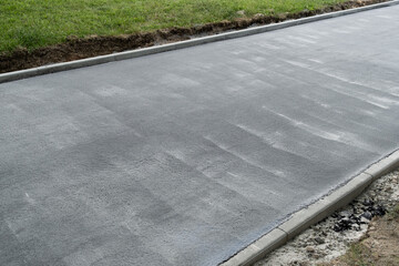 Fototapeta premium New asphalt on the walkway. Road construction site