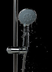 Shower head leak water from hoses plumbing in bathroom as water clogged drop. Black background...