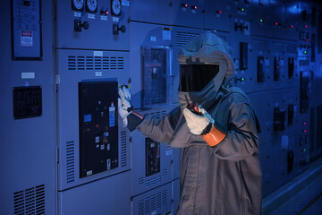 Engineer wears a arc flash protection suit for inspection electrical current and checking status...