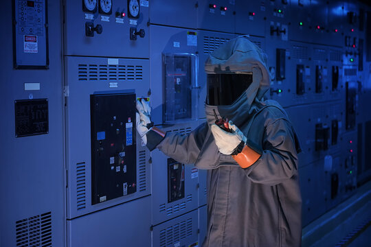 Engineer wears a arc flash protection suit for inspection electrical current and checking status switch gear electrical energy distribution substation, safety suit.