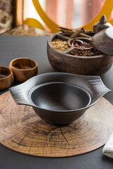 black bowl on wooden board with dry spices