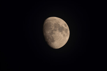 Partial moon with visible craters in the night sky.