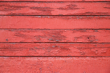 Texture of the old cracked wooden wall painted in red as a background