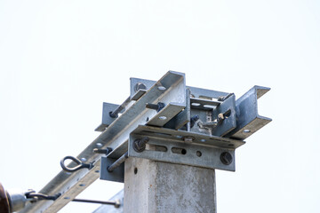 Steel bolt and nut on metal plates of concrete post, metal structure for supporting equipment of high voltage pole.