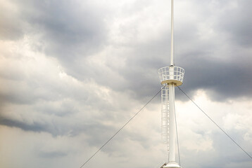 crow's nest  for spotting on the mast of a sailing yacht background with storm clouds.