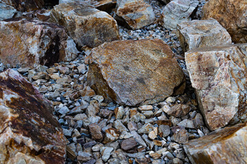 A close-up view of large rocks and smaller gravel, creating a textured pattern against the backdrop...