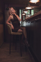 Fototapeta premium A girl is relaxing in a cafe, drinking coffee at the bar.
