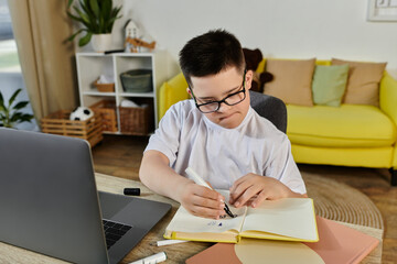 A young boy with Down syndrome sits at a table in his home, intently focused on his work.