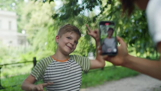 Capturing a joyful moment, a mom records her child dancing on her cellphone, illustrating the sharenting trend of sharing kids' lives online
