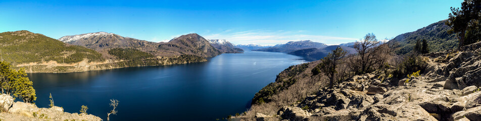 Panoramic view of snow-covered Lacar Lake (Argentina), spring afternoon in the Andes mountain range.