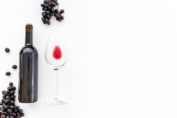 Red wine in the bottle with bunch of grapes and glass, top view