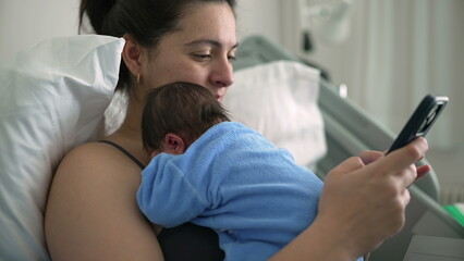 New mother in hospital bed using smartphone with newborn baby on chest, balancing parenting and...