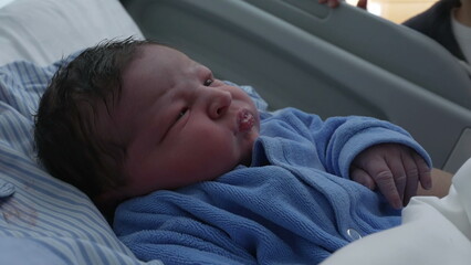 Newborn baby close-up face resting at hospital clinic after birth during the initial days of life