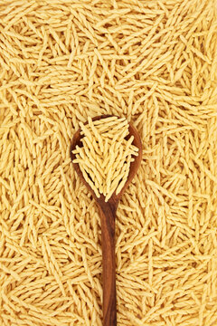 Trofie pasta food background with olive wood spoon. Traditional Italian cuisine made from durum wheat.