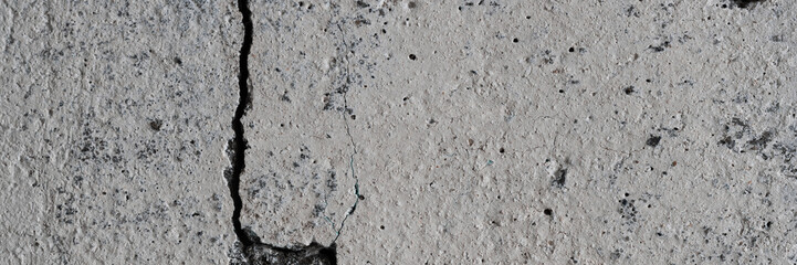 Texture of old cracked concrete wall. Rough gray concrete surface. Wide panoramic background for design.