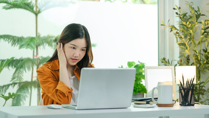 Beautiful young entrepreneur working with laptop at home office.