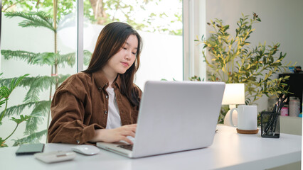 Fototapeta premium Beautiful young entrepreneur working with laptop at home office.
