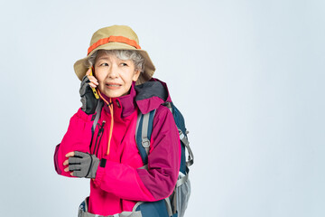 怯えてスマホで通話する登山服のシニア女性