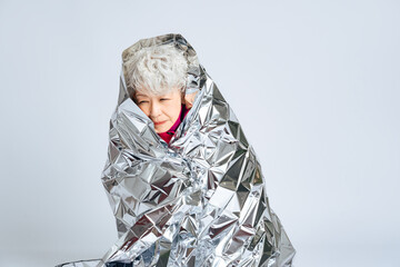 サバイバルシートに包まるシニア女性