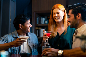 Group of Cheerful People toasting cocktail glass celebrating holiday event party together at luxury restaurant bar. Happy man and woman friends enjoy and fun hangout meeting nightlife at nightclub.